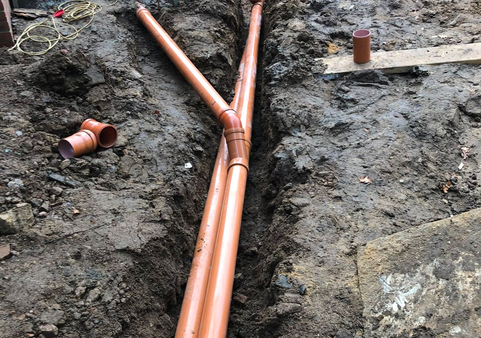 A driveway excavated to depth with a compacted sub-base and drainage being laid