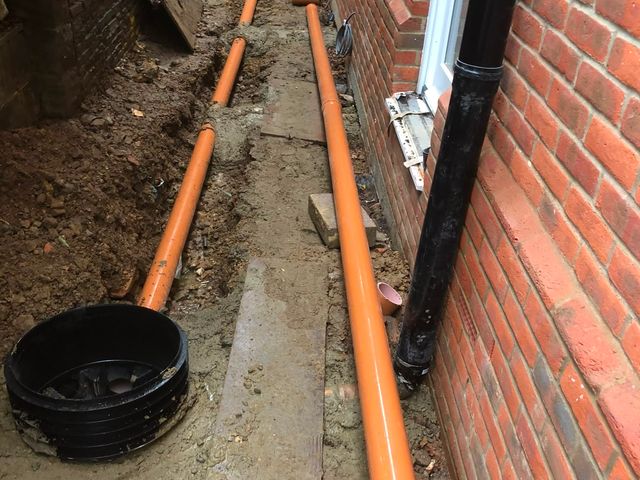 Kerbs and edge restraints being set on concrete during groundworks